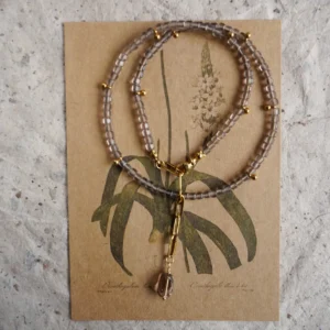 Handmade beaded ice obsidian necklace with a smoky quartz pendant on a vintage card.