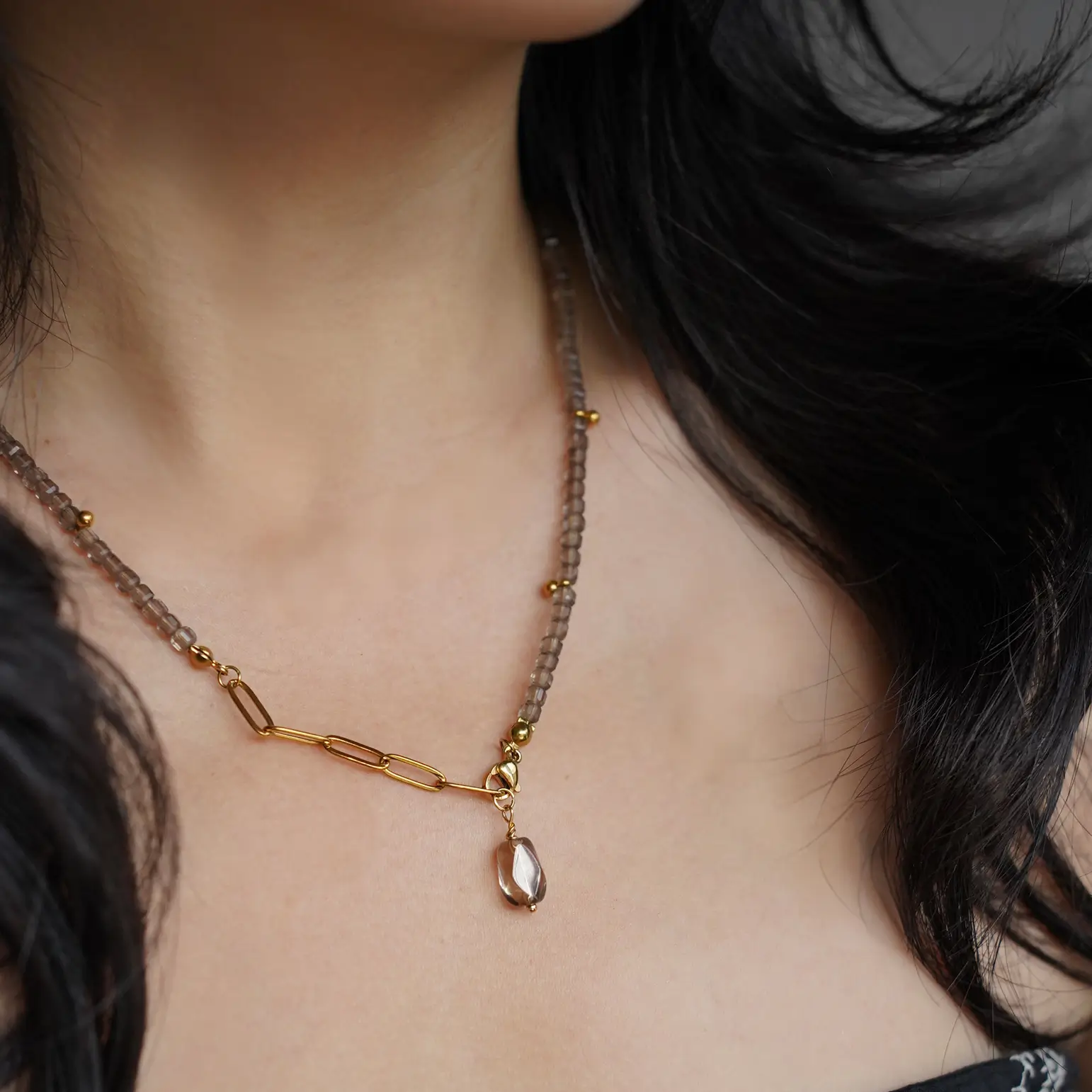 Close-up shot of a woman wearing a handmade obsidian beads Y-drop necklace.