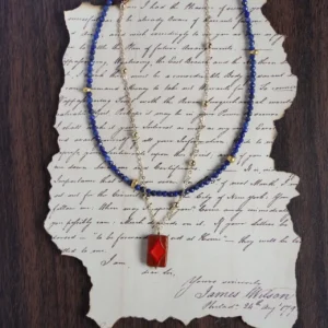 Layered blue lapis lazuli beads with a gold chain necklace.