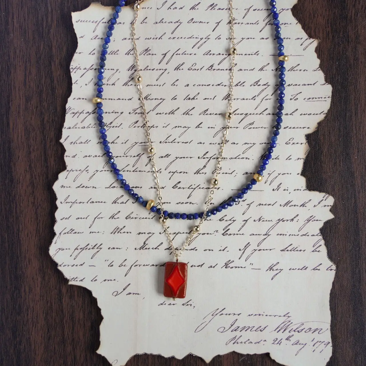 Layered blue lapis lazuli beads with a gold chain necklace.