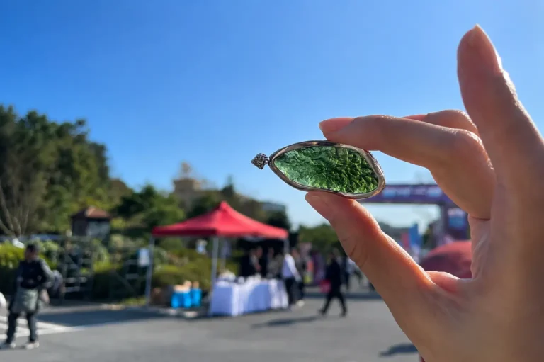 Natural Moldavite tektite pendant showing translucent green color in sunlight