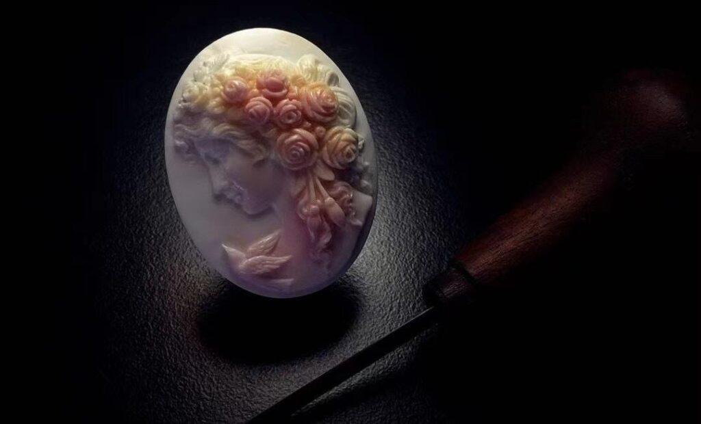 Hand-carved Queen Conch cameo featuring a classical female portrait with layered shell details.