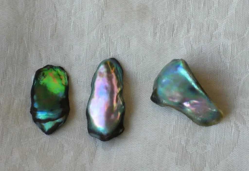 Natural pearls showing curved freeform shapes and colorful iridescence.