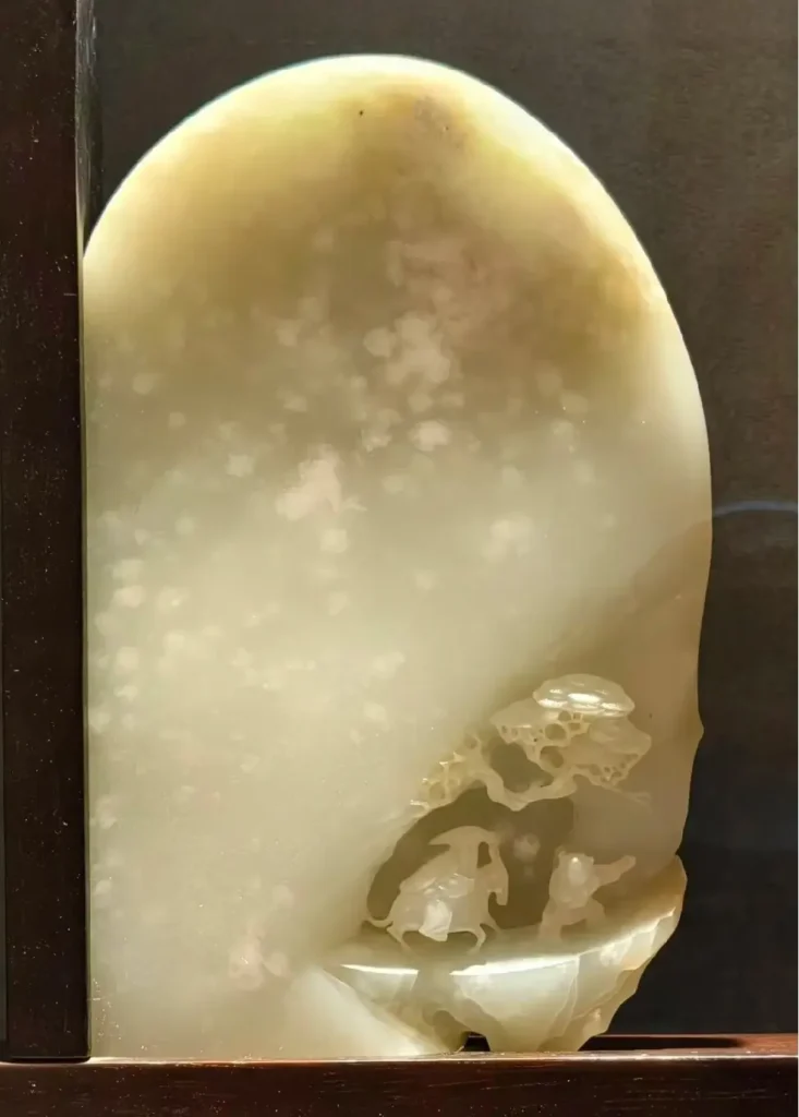 Hetian jade Feng Xue Ye Gui Ren carving showing white cotton inclusions as falling snow.