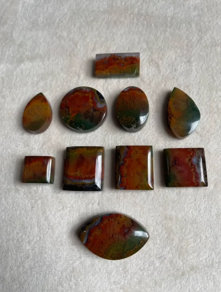 Collection of Iranian plume agates with orange-red, green, and yellow inclusions.