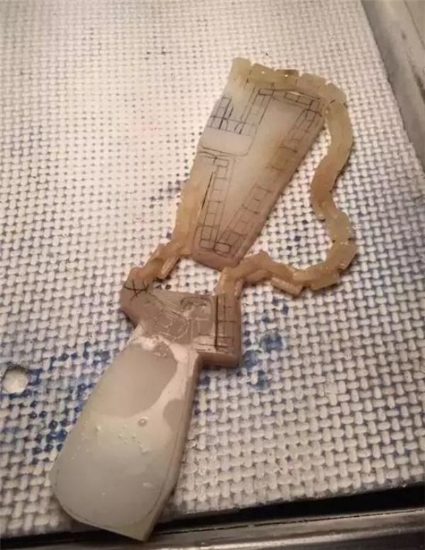 Partially released jade chain links being tested for smooth movement during carving.