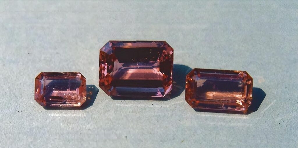 Three faceted pink Topaz gemstones from Pakistan with purplish pink hues.