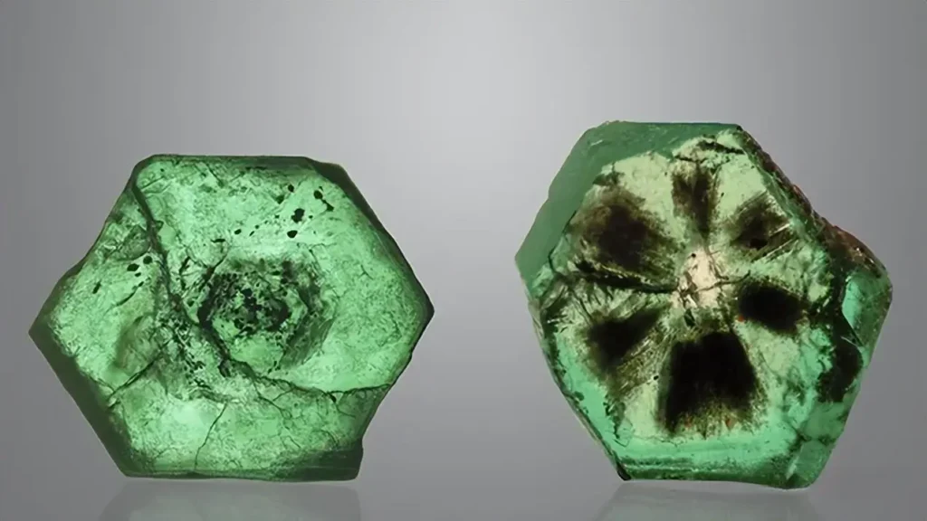 Two hexagonal polished trapiche-like emerald slices from Pakistan with radial patterns.
