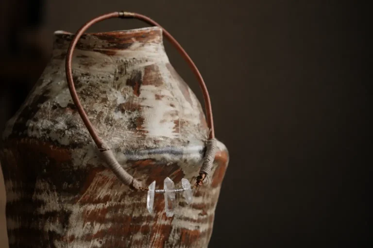Raw clear quartz pendant necklace with three natural crystal points and a brown leather cord.