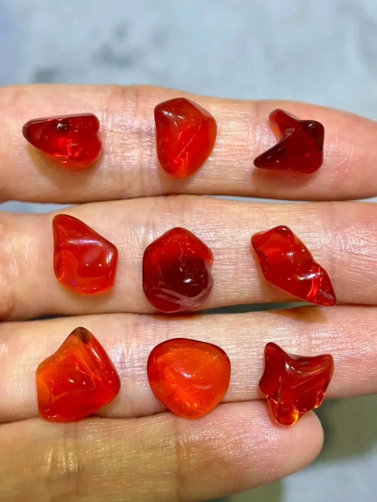 Transparent red fire opals with warm orange undertones, shown as a ruby alternative in freeform shapes.