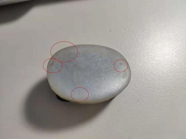 Resin cameo base showing small air bubbles highlighted with red circles on the surface.
