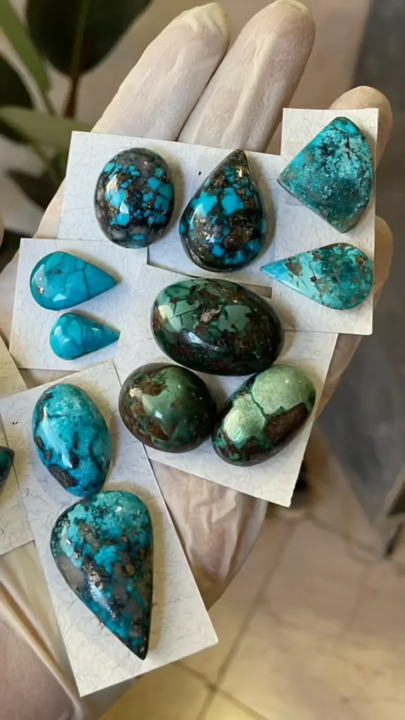 Polished Shahr-i Babak turquoise gemstones showing deep blue, green tones, and web-like matrix patterns.