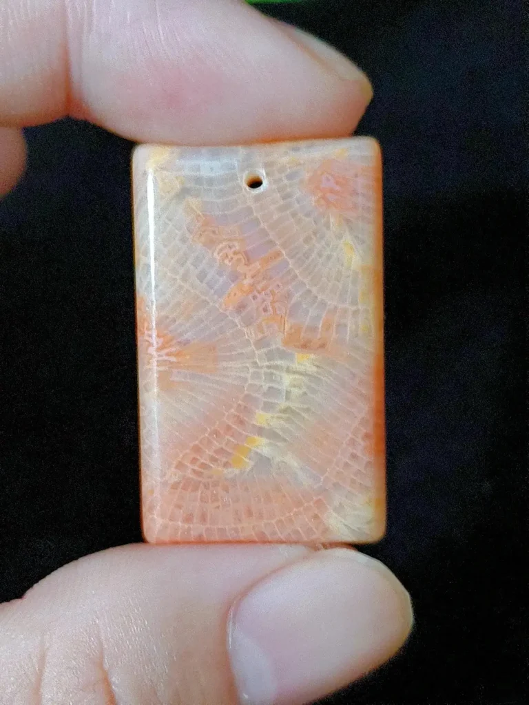 Square pendant with warm orange lines resembling phoenix feathers