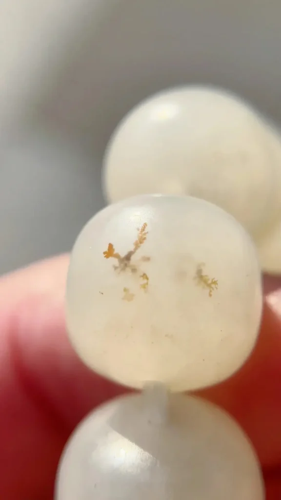 Close-up of beads showing water-grass-like inclusions.