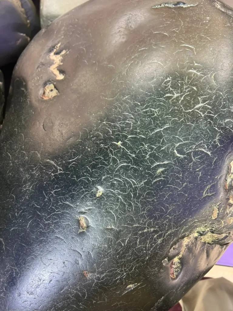 Clear nail-shaped marks across the skin of a large piece of Hetian seed jade