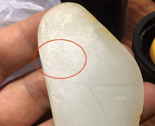 Grinding marks visible along the edge of imitation Hetian seed jade.