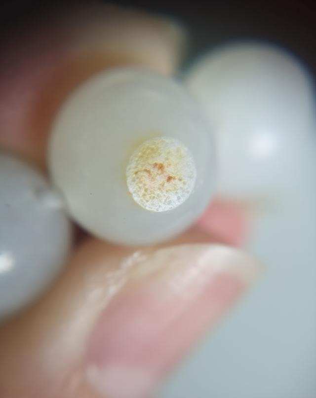 Close-up of a mountain jade bead with a small patch of imitation seed-jade skin.