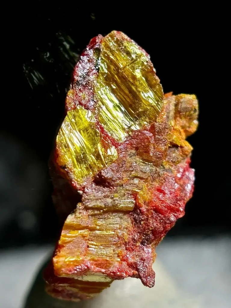 A natural mineral specimen showing golden-yellow orpiment and translucent red realgar occurring together.