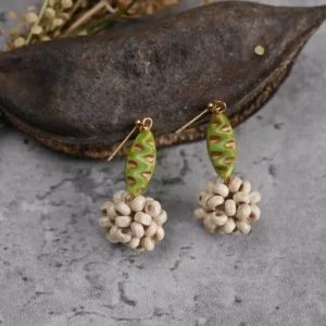 A pair of vintage earrings with olive green textured beads and beige wooden bead clusters.