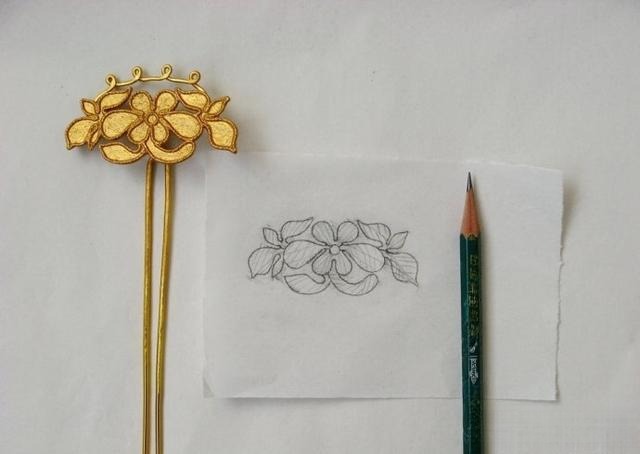 Pencil drawing showing the planned direction and arrangement of feather-like strands on a traced metal hairpin pattern.
