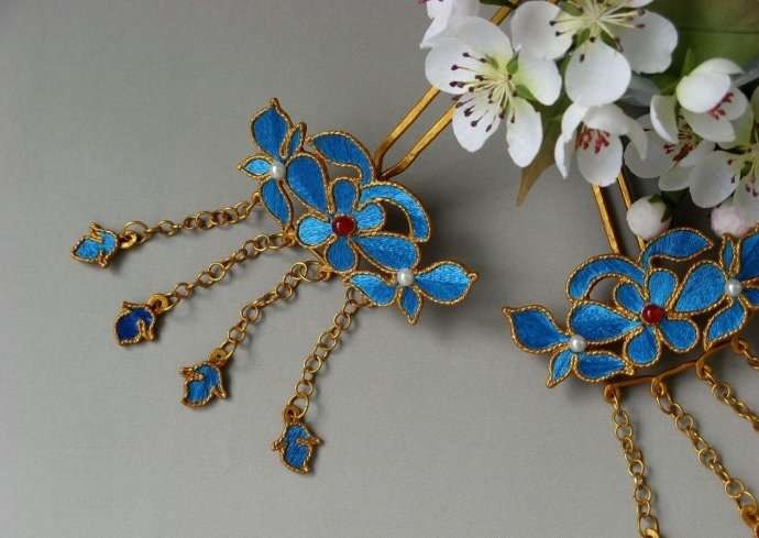 A pair of finished metal hairpins featuring blue satin ribbon, made using the Ribbon Diancui technique.