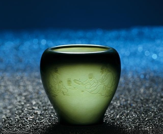Polished green nephrite vessel with thin translucent walls and carved decoration