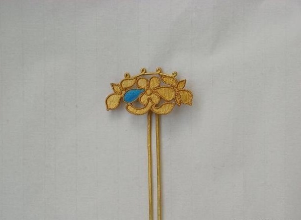 Trimmed blue ribbon pattern fitted into the recessed section of a metal hairpin base.