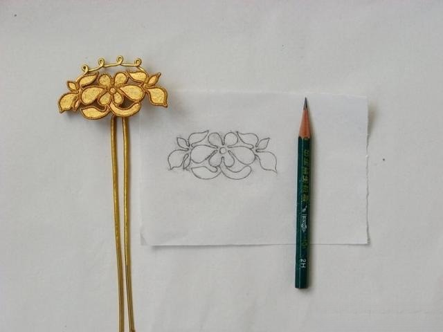 Pencil tracing of the filigree pattern on a metal hairpin base.